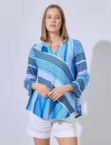 Blusa estampada a rayas azules y blancas, de la marca Ruby Rd. Tiene cuello a la base con escote en V y mangas tres cuartos regulables con presilla y botón.