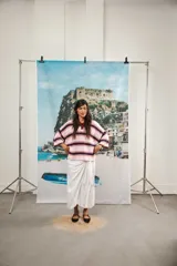 Remera rosa con rayas horizontales azul marino y bordó, cuello tipo polo marrón con botones y mangas cortas amplias.