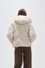 Campera puffer de cuello alto con capucha integrada, cierre frontal y diseño acolchado con costuras onduladas. Presenta mangas largas y bolsillos laterales.