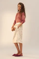 Bolso tipo pouch con textura de piel de serpiente en tonos degradados de rosado y bordó. Cuenta con una cadena dorada extraíble y cierre superior mediante clip.