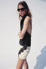 Falda pantalón cruzada de color crudo con detalle de encaje negro a contraste en el delantero y cierre posterior con cremallera oculta.