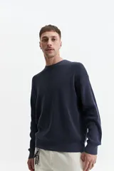 Buzo de punto oversize color azul marino, con escote redondo y puños.