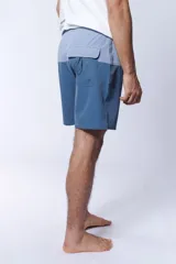 Short de baño bicolor con diseño en tonos celestes y azules, cintura elástica con cordón de ajuste gris y bolsillos laterales.