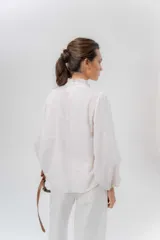 Camisa de manga larga color beige con diseño a rayas sutiles, cuello mao con volados y abertura frontal con detalles de volados a un lado.