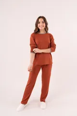 Conjunto de pijama color beige, compuesto por un buzo de manga larga con cuello redondo y un pantalón largo con cintura elástica.