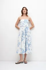 Vestido midi strapless con estampa floral azul sobre fondo blanco, con cinturón.