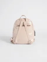 Mochila pequeña de cuero sintético color rosa claro, con dos compartimentos frontales con cierre negro.