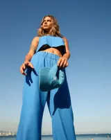 Pantalón de lino color azul, de corte oxford y tiro alto, con cintura elastizada y bolsillos laterales.