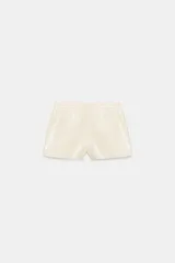Shorts de tiro bajo confeccionados en material sintético con acabado efecto piel, cuentan con bolsillos delanteros y cierre frontal con cremallera y gancho metálico.
