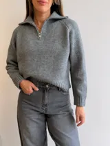 Sweater de tejido de punto color gris, con cuello polo y cierre frontal parcial, de manga larga y diseño relajado con puños y cintura acanalados.
