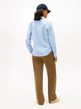 Camisa de corte regular confeccionada en popelín de algodón elástico con diseño de rayas verticales finas en color celeste y blanco. Presenta cuello clásico, cierre frontal con botones y logo de la marca bordado en el pecho.