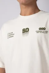 Remera de algodón premium con calce oversize y cuello redondo. Presenta un diseño minimalista con estampados gráficos en color verde oliva en la parte frontal superior.