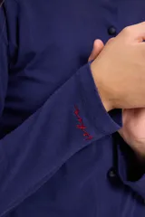 Blusa de algodón con cuello redondo, manga larga y cierre frontal con botones a tono. Presenta un diseño ajustado al cuerpo.