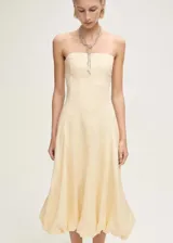 Vestido midi strapless de lino color beige, con diseño evasé y bajo abullonado.