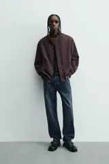 Cazadora azul marino de corte regular fit, confeccionada en tejido técnico repelente al agua. Presenta cuello subido, manga larga, bolsillos de vivo en cadera, bolsillo interior y acabados en rib en puños y bajo. Cierre frontal de cremallera oculta por solapa con botones a presión.