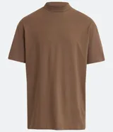 Remera blanca de algodón, corte holgado, cuello redondo alto, manga corta y sisas caídas.