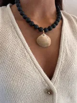 Chaleco de punto color crudo con escote en V y botones dorados.