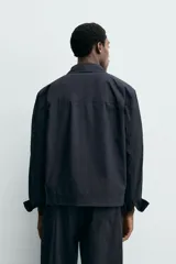 Sobrecamisa regular fit confeccionada en popelín de algodón color negro, con cuello solapa, bolsillos de plastrón en el pecho y cierre frontal con botones.