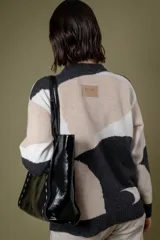 Buzo de punto con diseño abstracto que simula un paisaje, cuello redondo y mangas largas. Confeccionado en lana, presenta una combinación de colores en tonos beige, celeste y gris.