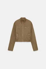 Chaqueta de cuello subido con cierre frontal de cremallera, bolsillos delanteros con cremallera y detalle de tachas metálicas decorativas en mangas y cuerpo. Cuenta con forro interior.