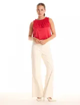 Blusa sin mangas color rojo, confeccionada en satén labrado con un patrón sutil de corazones. Presenta cuello alto con detalle de punto smock fruncido.