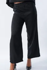 Pantalón palazo negro con estampado animal print, cintura elastizada con lazo y corte amplio.