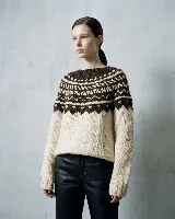 Buzo de tejido de punto con diseño de jacquard en el canesú y en los puños, de cuello redondo y manga larga.