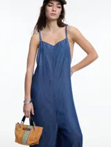 Enterito de denim suave confeccionado en 100% lyocell, con escote recto y breteles finos regulables que se ajustan en la espalda. Presenta una silueta amplia de pierna recta, caída fluida, bolsillos traseros aplicados y costuras a contratono.