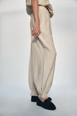 Pantalón de tiro medio con cintura elástica, bolsillos delanteros y bajo acabado en puño con lazada ajustable.