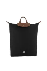 Mochila de diseño minimalista en color negro, con solapa superior y asas en color marrón. Presenta un aplique metálico con forma de labios en la parte inferior frontal.