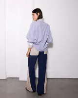 Pantalon de pana azul marino con corte semi oxford, presenta paneles laterales y bolsillos frontales con estampado floral en tonos beige.