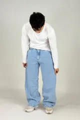 Pantalón jean celeste de corte amplio, estilo cargo, con bolsillos laterales y traseros.