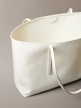 Cartera tipo tote de color blanco con estampado sutil de monograma CK de Calvin Klein, asas dobles largas y monedero o neceser mini incorporado con cierre.