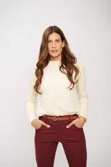 Buzo de tejido liso color crema, de manga larga y cuello redondo.