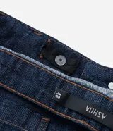 Bermuda tipo jorts de corte amplio y tiro medio, confeccionada en denim de algodón azul oscuro. Presenta diseño de cinco bolsillos, cierre frontal con botón y costuras en tono contrastante.