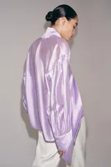 Camisa de ZARA Woman Collection confeccionada en hilatura con mezcla de lyocell, de color blanco marfil. Presenta cuello redondo, escote en V con lazadas en el mismo tejido, manga larga con puño y bajo recto.