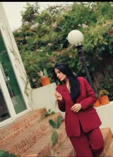 Blazer bordeaux de corte clásico, con solapas de muesca, cierre frontal con botón y bolsillos con solapa.