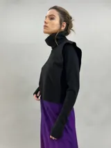 Buzo de jersey de lana color negro, con cuello elevado, hombreras estructuradas y mangas largas con puños con ojal para el pulgar.