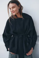 Trench corto de Zara, confeccionado en mezcla de lyocell, color verde militar. Presenta cuello solapa, manga larga con hombro caído y puños con trabilla. Incluye bolsillos delanteros de plastrón, cierre frontal cruzado con botón y cinturón de lazada en el mismo tejido.