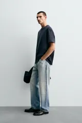 Camiseta de corte relajado confeccionada en tejido de algodón compacto. Presenta cuello redondo con acabado de rib doble y mangas cortas. Su apariencia única es resultado de un proceso especial de tintado y acabado.