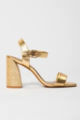 Sandalias de tacón alto color lila, con tira delantera y tobillera con hebilla dorada.