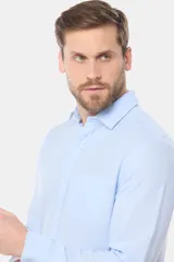 Camisa celeste de lino de manga larga con bolsillo en el pecho y botones personalizados.