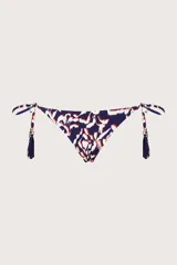 Bombacha de bikini con tiras laterales ajustables, decoradas con borlas colgantes. Presenta un estampado abstracto en tonos azul marino, blanco y naranja.