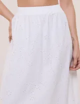 Falda maxi de algodón blanco con diseño de broderie, tiro alto con pretina elástica y corte evasé.