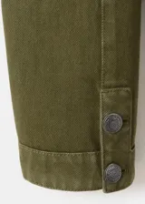 Chaqueta estilo militar color verde militar, confeccionada en algodón, con cuello alto, cierre frontal de cremallera y doble botonadura metálica decorativa.