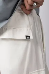 Bermuda cargo de lino y rayón color blanco, con bolsillos laterales tipo cargo, cintura elástica con cordón ajustable y calce relajado.