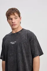 Remera oversize de algodón con efecto acid wash y diseño boxy, de mangas corta con estampa frontal pequeña y sutil.