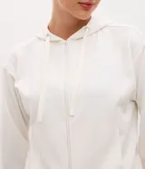 Campera deportiva de corte regular confeccionada en modal, con cierre frontal por cremallera, capucha con cordón ajustable, mangas largas con puños elásticos y bolsillos laterales.