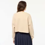 Buzo de cuello redondo en felpa color beige, con diseño estampado frontal con la inscripción 'NEW YORK 90 EAST VILLAGE' en color marrón. Presenta corte holgado y ruedo con terminación al corte.