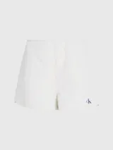 Shorts de mujer color blanco roto, confeccionados en sirsaca de algodón. Tienen un corte regular, cintura con cordón ajustable, bolsillos laterales y bolsillos traseros de ojal. Presentan una insignia con el logo de Calvin Klein en el bajo.